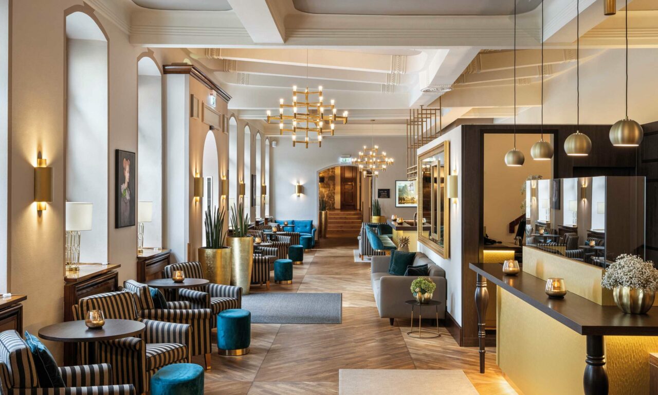 elegante Lobby hotel recklinghausen mit Sesseln Kornleuchtern und Tischen im parkhotel engelsburg romantik hotel nrw